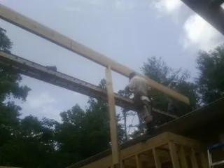 Carpenter setting a ridge beam over a new addition frame — Ice Dam Removal by Roofing Brothers in Jennings