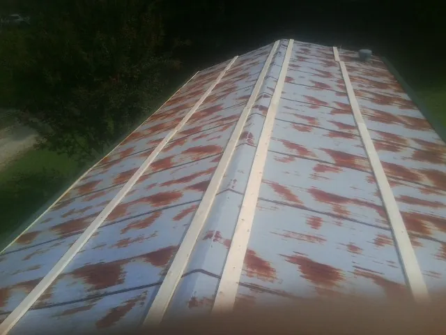 Rusted metal roof panels with new wood purlins before replacement — Storm Damage Roof Repair in Jennings by Roofing Brothers