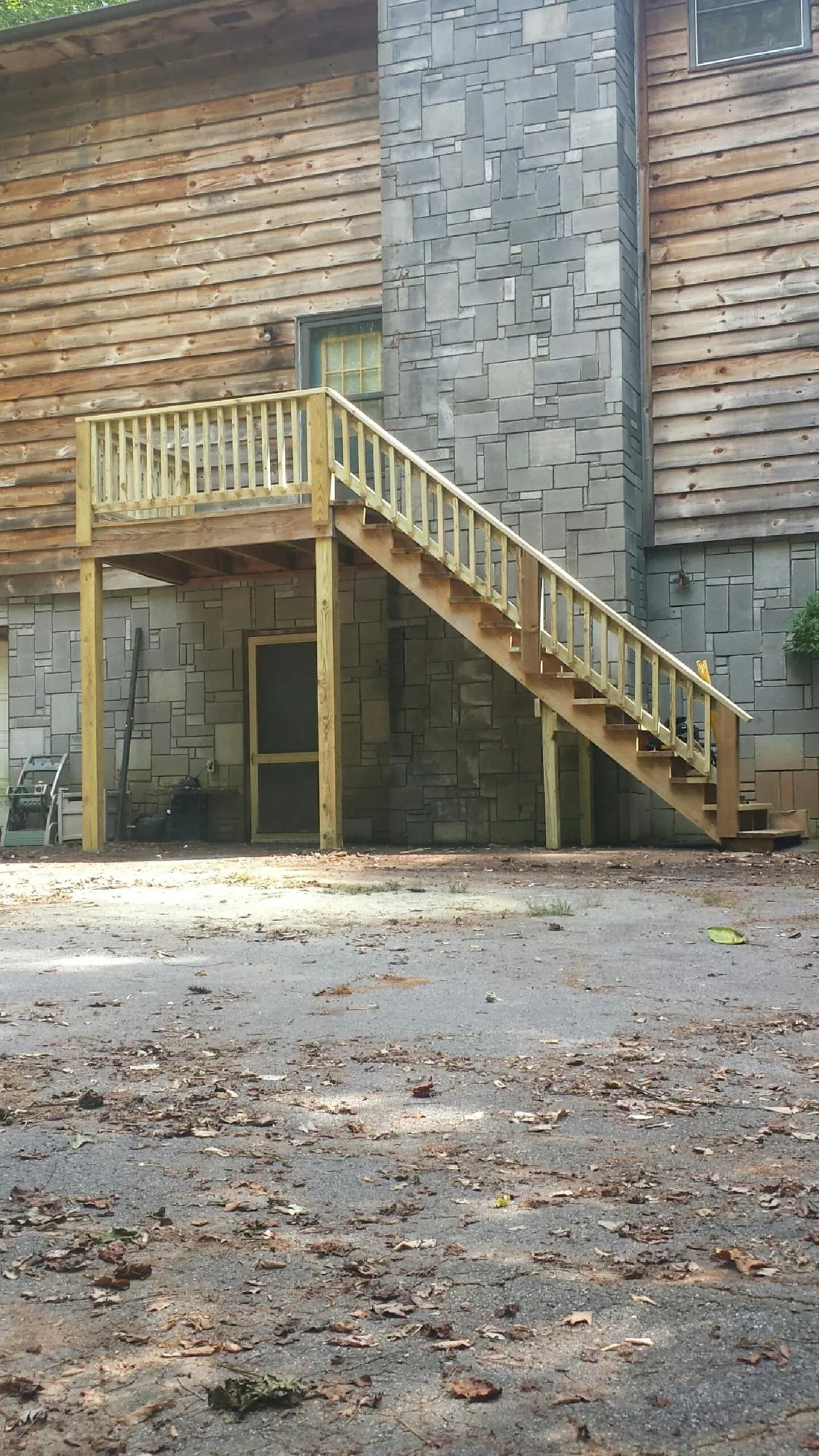 New pressure treated deck and stair landing on a log home in Jennings
