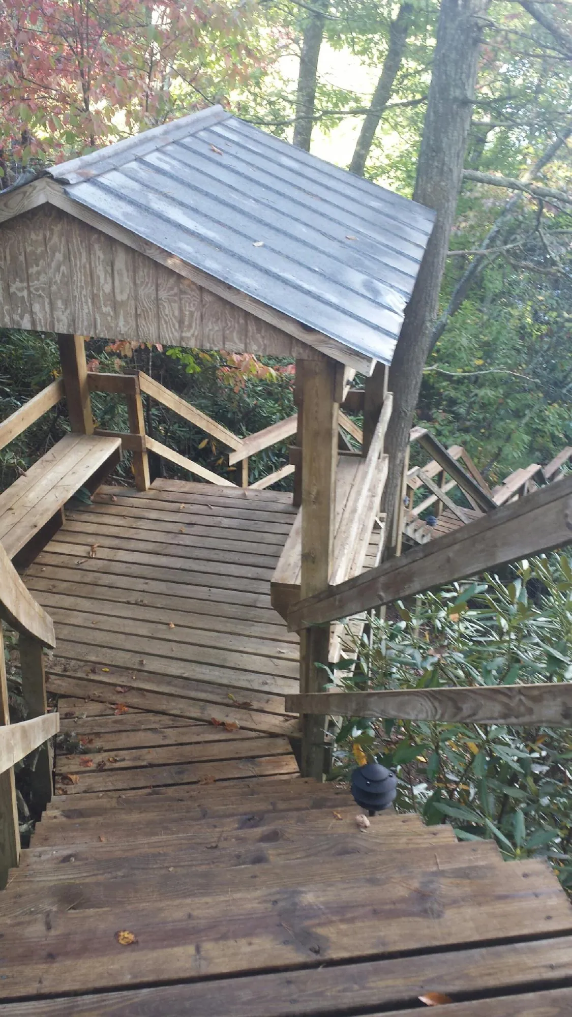Metal roofed shelter over wooden steps on a wooded walkway — Skylight Repair & Installation work by our crew in Jennings
