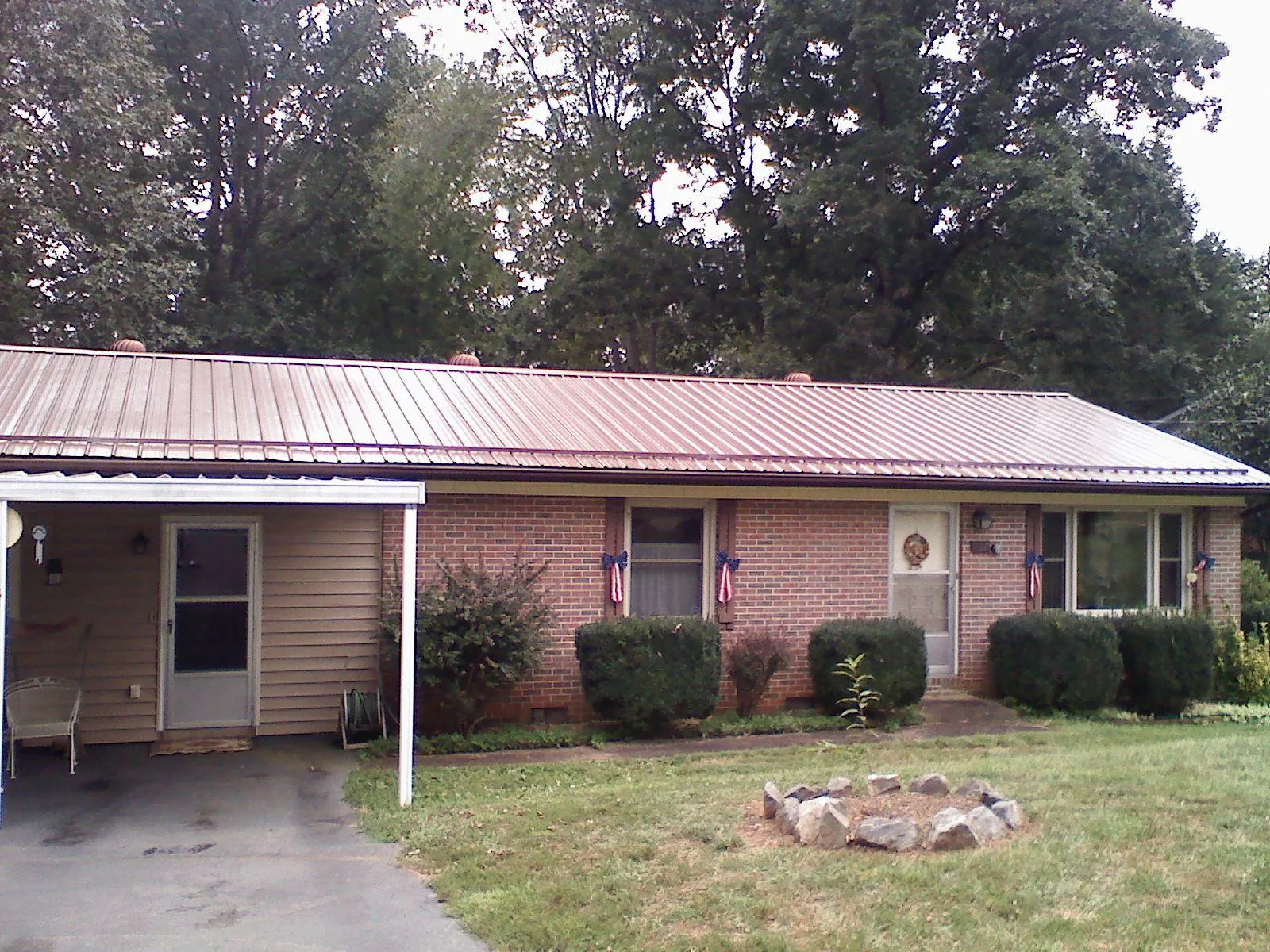 Bronze metal roof and carport on a brick ranch home — Roof Repair work by our crew in Jennings